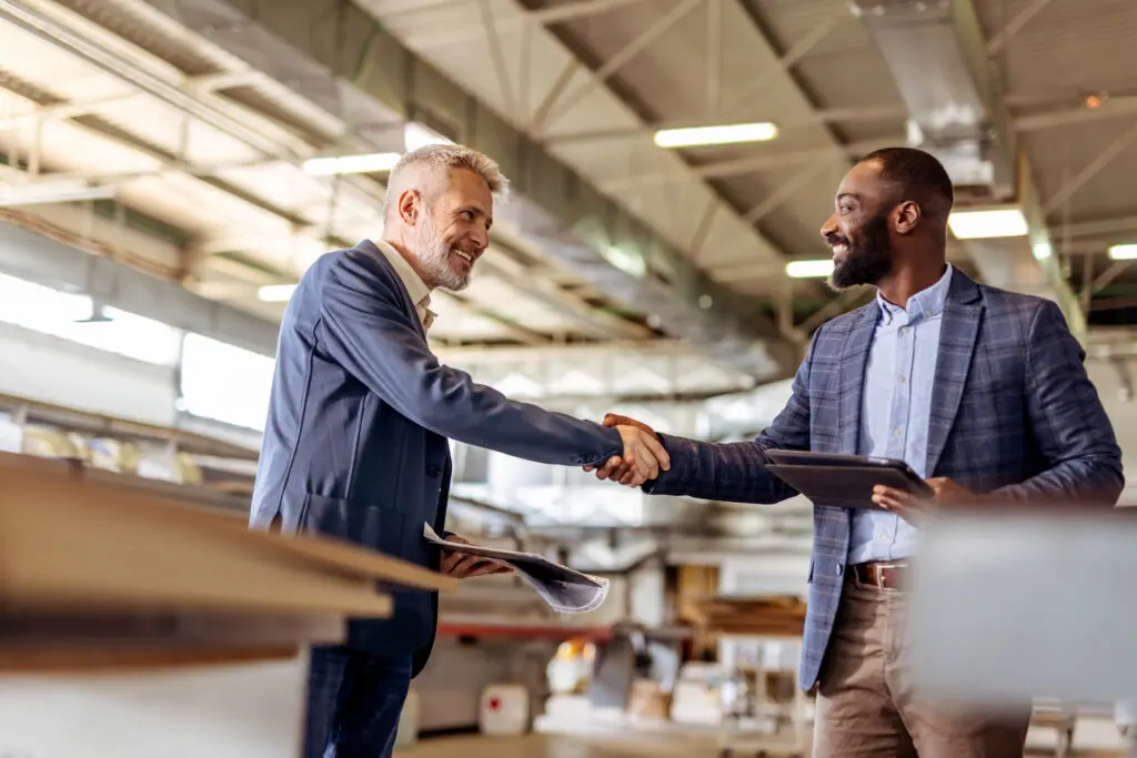 Professional Businessmen Shaking Hands During Commercial Agreement in a Modern Factory Employer Partners