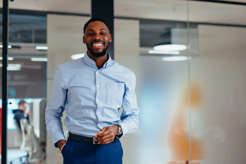 Confident young businessman smiling in modern office Employer Partners